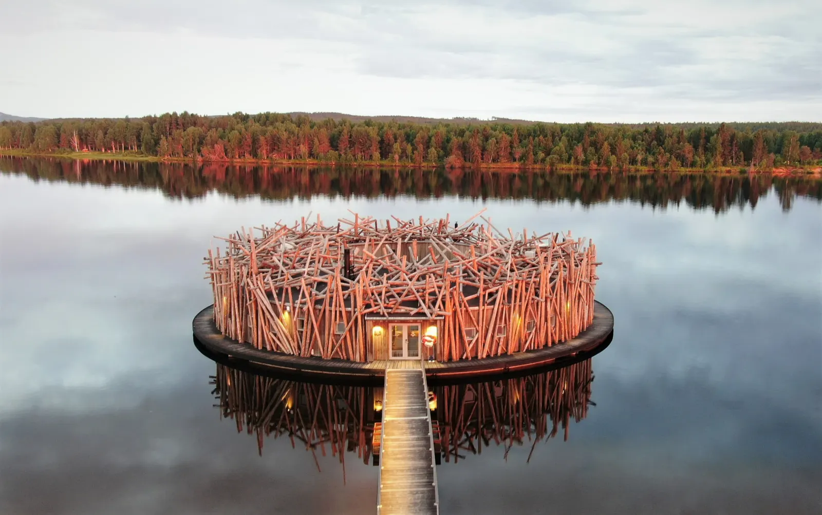 Arctic Bath, a circular timber retreat floating on a still river in Swedish Lapland